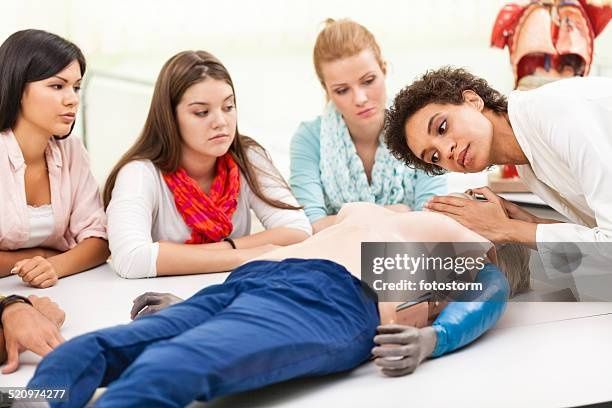 RN instructor demonstrating CPR and AED technique to a small group during a mobile training class